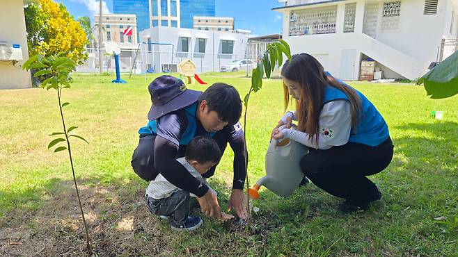 국제청소년연합(IYF) 산하 굿뉴스코 푸에르토리코 해외봉사단 단원인 조연아(오른쪽)·김승혁씨가 22일 지구의 날을 맞아 IYF 센터에서 현지 교민 어린이와 과나바나 묘목을 심고 있다. /IYF 굿뉴스코 해외봉사단