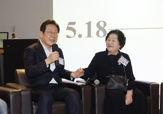 이재명 더불어민주당 대선 경선 후보(왼쪽)가 24일 광주 전일빌딩245에서 ‘대한민국 민주화를 이끈 시민들’을 주제로 열린 간담회에서 고(故) 문재학 열사 어머니인 김길자씨의 손을 잡고 발언하고 있다. 이 후보는 이날 “광주정신은 헌법 전문에 게재하는 게 맞다”고 말했다. [연합뉴스]