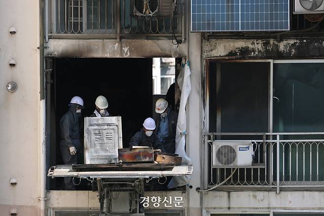지난 21일 화재가 발생했던 서울 관악구 봉천동 아파트에서 25일 관계자들이 불 탄 집기를 사다리차에 싣고 있다. 정효진 기자