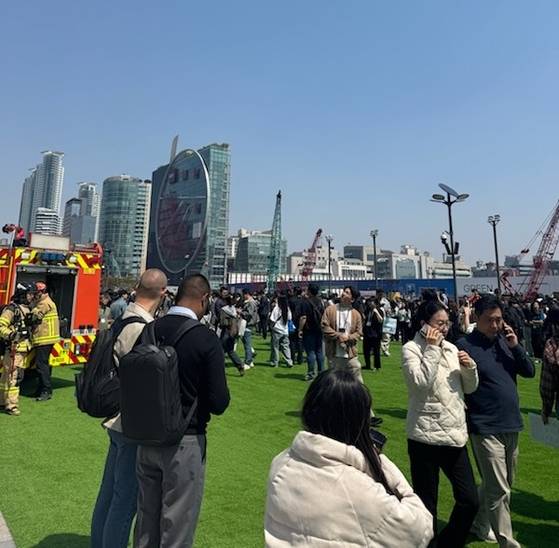 Visitors and tourists are seen outside of Coex in Gangnam District, southern Seoul after they evacuated the convention center following a fire that broke out on April 25. [JOONGANG PHOTO]