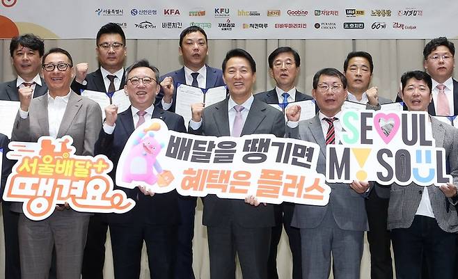 25일 서울시 중구 서울시청에서 서울시 및 신한은행, 18개 치킨 프랜차이즈가 ‘서울배달플러스 가격제’ 도입을 위한 상생 협약을 체결하고 정상혁 신한은행장(앞줄 왼쪽 둘째), 오세훈 서울시장(앞줄 가운데), 프랜차이즈 대표 및 관계자들이 기념 촬영하는 모습. [사진 제공 = 신한은행]