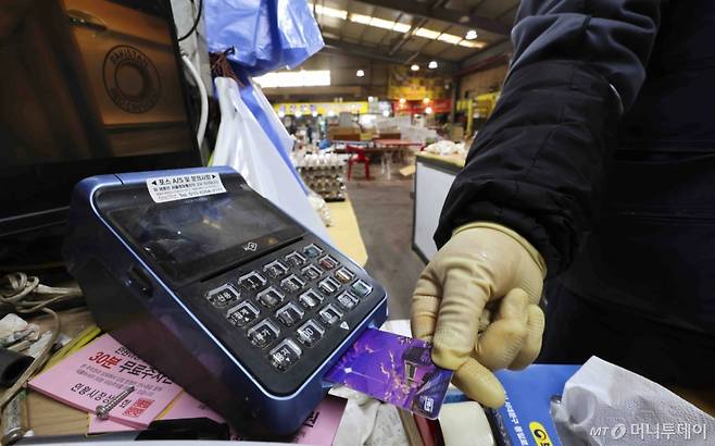 [서울=뉴시스] 김근수 기자 = 14일 서울 시내의 한 점포에서 점주가 신용카드로 물건을 결제하고 있다.