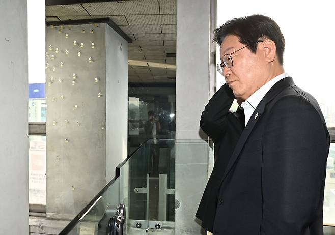 24일 오후 광주 동구 전일빌딩 245에서 이재명 더불어민주당 대선 경선 후보가 1980년 5월 당시 계엄군의 헬기사격에 의한 탄흔을 살펴보고 있다. [연합]