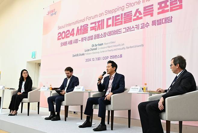 오세훈(가운데) 서울시장이 지난해 10월 7일 서울 중구 동대문디자인플라자DDP에서 열린 ‘2024 서울 국제 디딤돌소득 포럼’에서 대담하고 있다.  [서울시 제공]