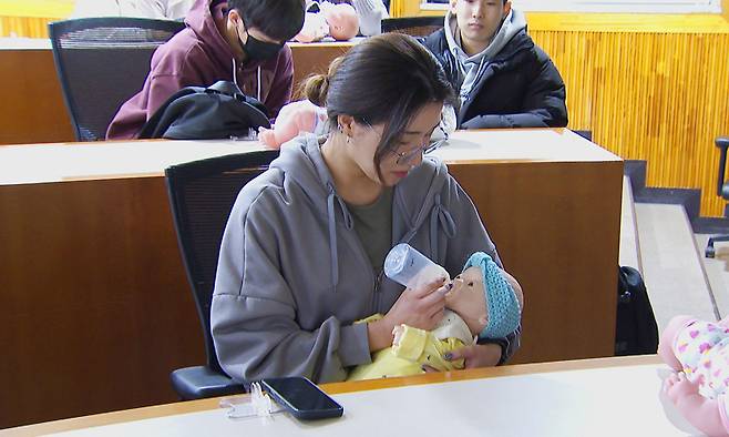 3일 경기 용인시 처인구의 용인예술과학대에서 열린 ‘휴머노이드 아기돌봄 체험’에서 한 여학생이 젖병을 물리고 있다. 용인시 제공
