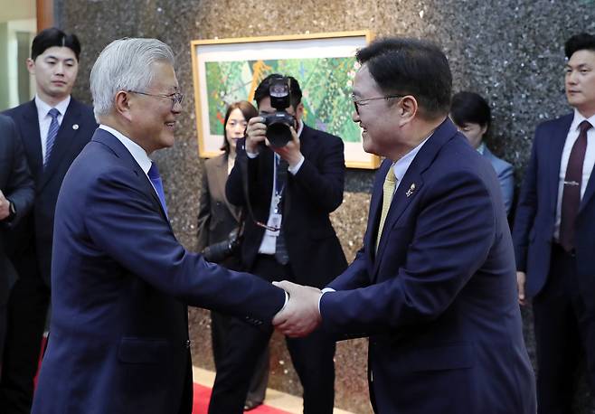 문재인 전 대통령이 25일 서울 여의도 국회 의장접견실 앞에서 우원식 국회의장 면담에 앞서 인사를 나누고 있다.