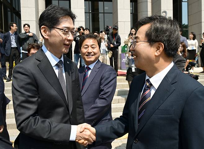 더불어민주당 김경수, 김동연 대선 경선 후보가 25일 서울 여의도 국회도서관에서 열린 4·27 남북 판문점선언 7주년 기념식에 참석하며 인사를 나누고 있다.