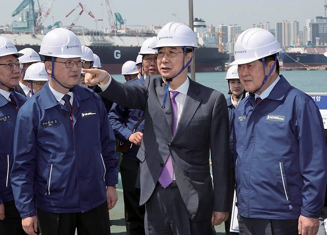 한덕수 대통령 권한대행(가운데)이 4월16일 HD현대중공업 울산조선소에서 HD현대중공업 권오갑 회장(오른쪽) 등과 정조대왕급 2번함 '다산정약용함' 설명을 듣고 있다. ⓒ연합뉴스