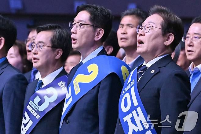 26일 오후 광주 서구 김대중컨벤션센터에서 열린 더불어민주당 21대 대통령선거 후보자 선출을 위한 호남권 합동연설회에서 김동연(왼쪽부터), 김경수, 이재명 경선 후보가 애국가를 부르고 있다. 2025.4.26/뉴스1 ⓒ News1 김태성 기자