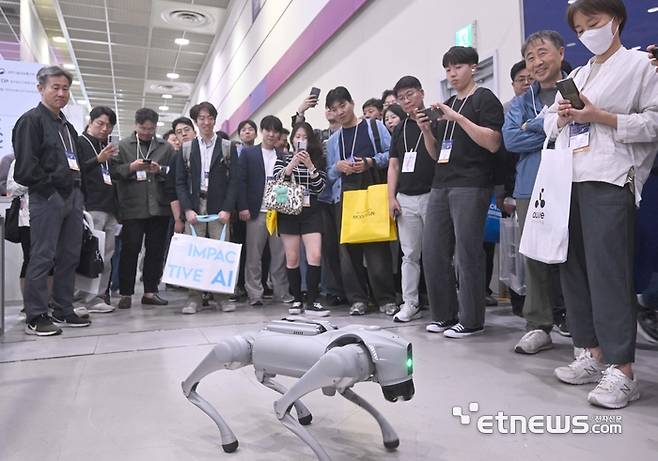국내 최대 정보통신기술(ICT) 축제 '월드IT쇼(WIS) 2025 ICT융합제조지능화진흥연구센터에서 한양대가 프로그래밍한 4족 보행로봇을 관람객들이 보고 있다.  박지호기자 jihopress@etnews.com