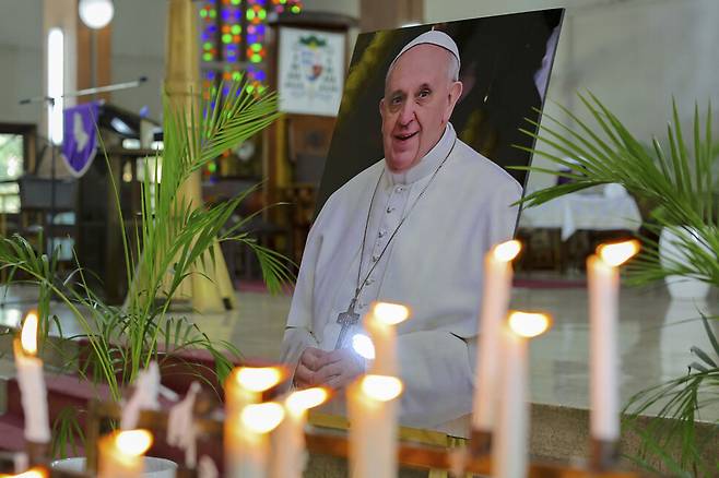 25일(현지시각)아크라 가나의 성령 대성당에서 열린 미사에서 촛불과 함께 놓인 프란치스코 교황 초상화. 바티칸/AP 연합뉴스