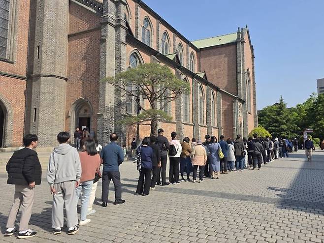 [서울=뉴시스] 고재은 수습기자 = 26일 오후 서울 종로구 명동성당 앞에 프란치스코 교황을 추모하기 위해 시민들이 줄을 서고 기다리고 있다. 2025.04.26. jeko@newsis.com *재판매 및 DB 금지