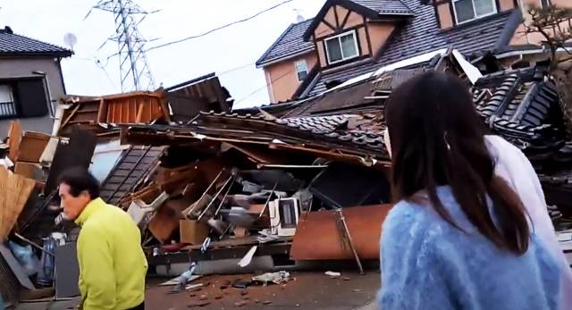 지난 2024년 1월 2일 일본 이시카와현 시카 지역에 전날 발생한 규모 7.6의 지진으로 주택들이 무너진 가운데 주민들은 물을 배급받기 위해 이동하고 있다. AFP연합뉴스