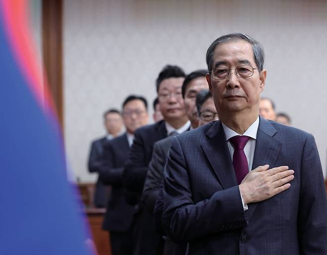 한덕수 대통령 권한대행이 4월14일 정부서울청사에서 열린 국무회의에서 국기에 경례하고 있다. ⓒ연합뉴스