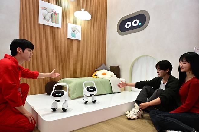 LG전자가 국내 최대 정보통신기술 전시회 '월드IT 쇼 2025'에 참가해 공감지능(AI)을 통해 변화하는 고객의 공간과 일상을 선보인다. 모델이 LG전자 직원에게 고객의 목소리와 표정·말투로 감정까지 파악하는 이동형 AI홈(Q9)의 설명을 듣고 있다./사진=LG전자