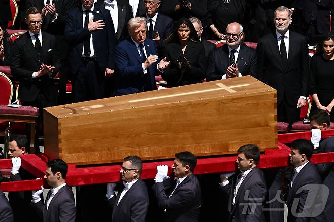 도널드 트럼프 미국 대통령과 멜라니아 트럼프 여사가 26일 오후(현지시간) 바티칸 성 베드로 광장에서 열린 프란치스코 교황의 장례 미사에 참석해 관이 운구되는 모습을 기켜보고 있다. ⓒ 로이터=뉴스1