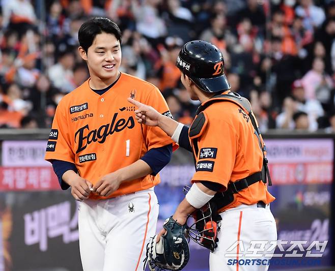 8회 이닝 종료 후 최재훈 포수와 대화를 나누는 문동주.
