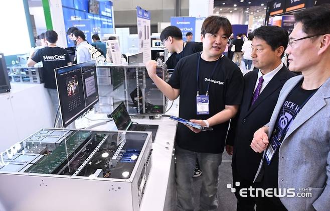 매니코어소프트는 24일 서울 코엑스에서 열린 '월드IT쇼(WIS 2025)'에서 액체 냉각 방식 텐스토렌트 칩등을 탑재한 AI 및 고성능 컴퓨터를 선보였다. 매니코어소프트 부스에서 박정호 매니코어소프트 대표(왼쪽 첫번째), 김홍욱 텐스토렌트 한국지사장(가운데), 윤덕노 웨이브파이브 대표가 AI 컴퓨팅 환경에 관해 이야기를 나눴다.