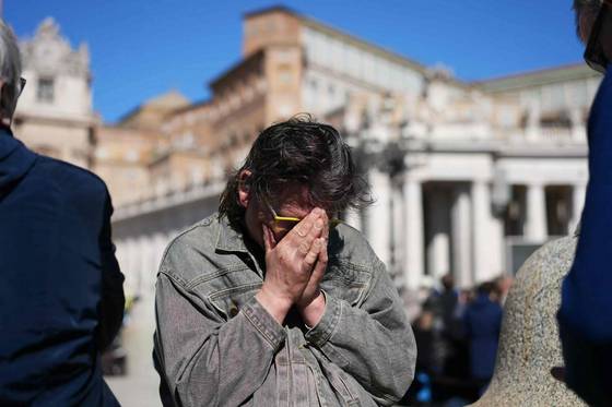 26일 프란치스코 교황의 장례 미사가 열린 성 베드로성당 광장에서 한 시민이 양손으로 얼굴을 감싼 채 애도하고 있다. AFP=연합뉴스