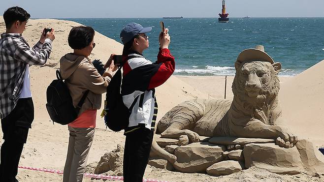 관람객들이 모래조각을 구경하고 있다. 송봉근 기자