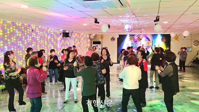 지난 22일 충북 충주시 교현동 충주노인복지관 지하에 마련된 ‘청춘나이트’를 찾은 노인들이 춤을 추고 있다.  이삭 기자.