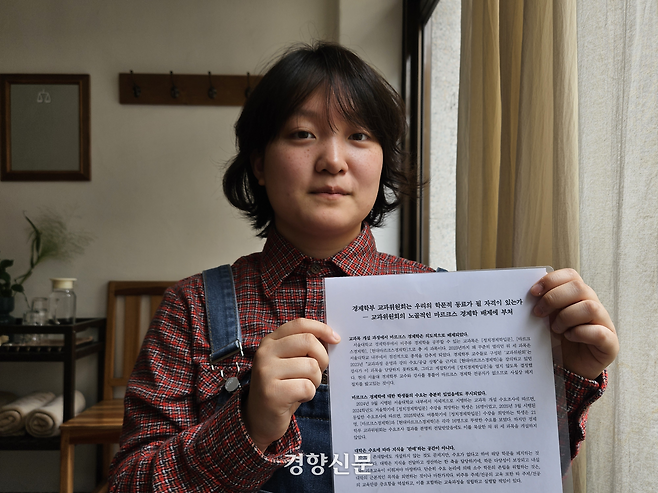 서울대학교 사회학과 3학년생 김선아씨(22)가 27일 서울 마포구의 한 카페에서 ‘경제학부 교과위원회는 우리의 학문적 동료가 될 자격이 있는가’ 대자보를 들고 있다. 박채연 기자