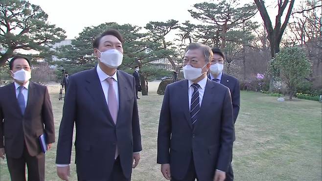 Former President Yoon Suk Yeol (second from left) and former President Moon Jae-in (third from left) meet at the former presidential office Cheong Wa Dae on March 22, 2022, almost two weeks after Yoon was elected president. (Presidential Archives)