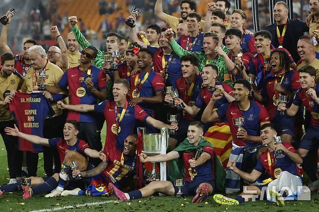 [세비야=AP/뉴시스] FC 바르셀로나 선수들이 27일(현지 시간) 스페인 세비야의 에스타디오 델 라 카르투하에서 열린 2024-25 코파 델 레이(국왕컵) 정상에 올라 트로피와 함께 환호하고 있다. 바르셀로나는 결승전에서 레알 마드리드와 연장 끝 3-2로 승리하고 우승컵을 들어 올렸다. 2025.04.27.