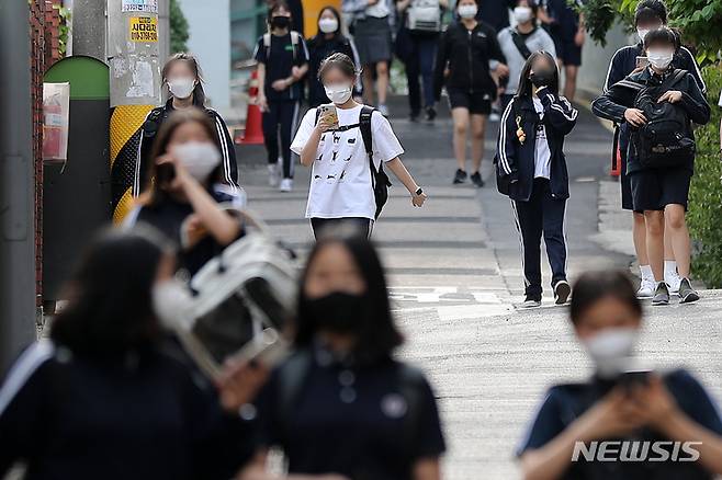 [서울=뉴시스] 백동현 기자 = 2022년 5월 25일 오후 서울 시내 한 중학교 앞에서 학생들이 스마트폰을 보면서 하교하고 있다. 2022.05.25. livertrent@newsis.com