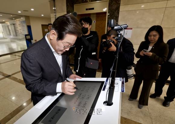 이재명 더불어민주당 대선 경선 후보가 17일 대전 유성구 국방과학연구소(ADD)에서 열린 현장간담회에 앞서 방명록을 작성하고 있다. 2025.4.17 대전 국회사진기자단