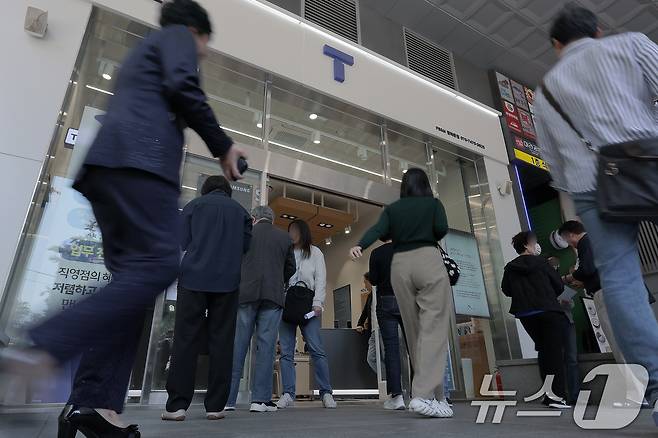 해킹 공격으로 가입자 유심 정보가 탈취된 SK텔레콤이 가입자 유심 무상 교체를 시작한 28일 오전 서울 종로구 T월드 매장 앞에서 고객들이 온라인 예약을 안내 받고 있다. 전국 T월드 매장 2600여 곳과 공항 로밍센터에서 희망하는 고객들에게 순차적으로 유심 무상 교체를 진행하는 SK텔레콤은 현재 유심 100만 개를 확보했으며 5월 말까지 약 500만 개를 추가 확보한다는 방침을 밝혔다. 2025.4.28/뉴스1 ⓒ News1 박정호 기자