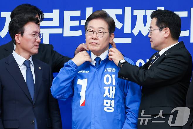 박찬대 더불어민주당 대표 직무대행 겸 원내대표가 28일 서울 여의도 국회에서 열린 최고위원회의에서 이재명 대선 후보에게 선거복을 입혀준 뒤 옷깃을 정리하고 있다. 왼쪽부터 한준호, 김민석 최고위원, 이 후보, 박 직무대행. 2025.4.28/뉴스1 ⓒ News1 안은나 기자