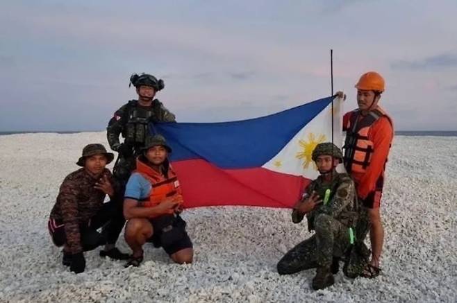 서필리핀해 국가 태스크포스(NTF-WPS)는 27일 남중국해 암초 3곳에 자국 보안군이 상륙했다고 밝히면서 보안군 5명이 암초에서 자국 국기를 펼친 사진을 공개했다. /NTF-WPS