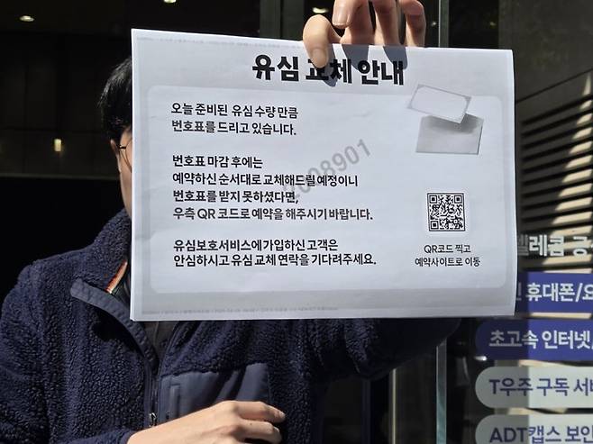 서울 강남 일대 SKT 대리점인 T월드 PS&M 뱅뱅사거리점에서 직원이 유심 교체 예약사이트 QR 코드를 안내하고 있는 모습. 사진=구자윤 기자