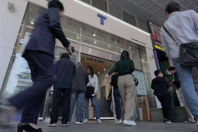 해킹 공격으로 가입자 유심 정보를 탈취당한 SK텔레콤이 유심 무상 교체에 나선 28일 서울 종로구 T월드 매장 앞에서 고객들이 온라인 예약을 안내받고 있다. 뉴스1