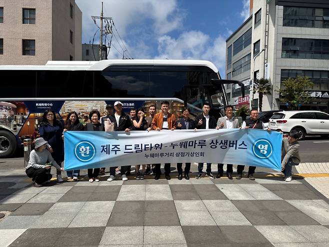 제주 드림타워-누웨마루 상생버스 출범을 기념해 관계자들이 함께 기념 촬영을 하고 있다. (롯데관광개발 제공)