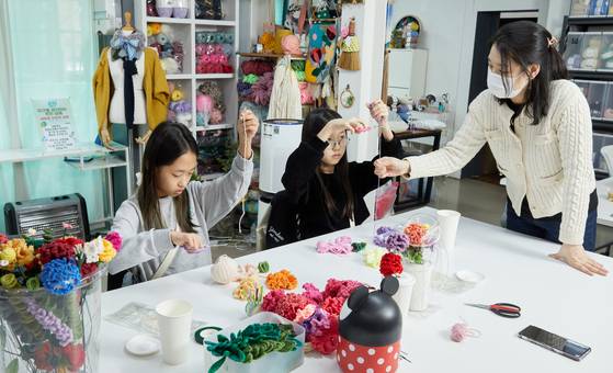 박수정(오른쪽) 작가의 도움을 받아 니트플라워로 나만의 카네이션 화분 만들기에 도전한 소중 학생기자단.