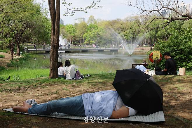 서울 낮 최고 기온이 26도까지 오르는 초여름 날씨를 보였던 지난 21일 서울 성동구 서울숲에서 시민이 더위를 피해 휴식을 취하고 있다. 한수빈 기자