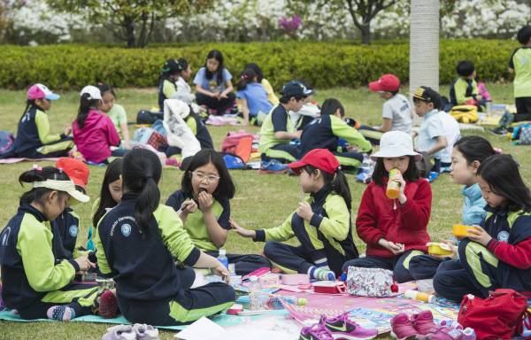 부산시민공원으로 봄소풍을 나온 부산의 한 초등학교 어린이들이 잔디밭에서 도시락을 먹으며 즐거운 한때를 보내고 있다. 국제신문DB