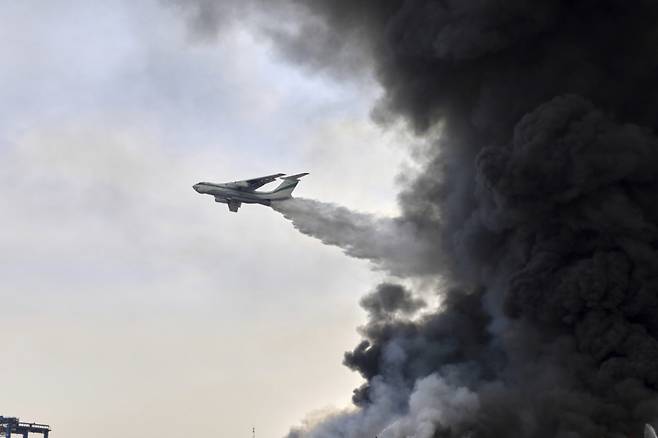 이란 혁명수비대 소방 항공기가 27일(현지 시간) 이란 반다르압바스 인근 샤히그라자이 항구 폭발 현장 상공에서 물을 뿌리고 있다. /AP=뉴시스