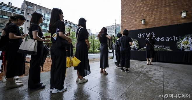 [서울=뉴시스] 정병혁 기자 = 서이초 순직교사 1주기인 18일 서울 서초구 서울교육대학교에서 열린 교사유가족협의회, 초등교사노동조합 2024 순직교사 추모행사를 찾은 교사 및 시민들이 헌화를 하기 위해 줄 서 있다.  2024.07.18. jhope@newsis.com /사진=정병혁
