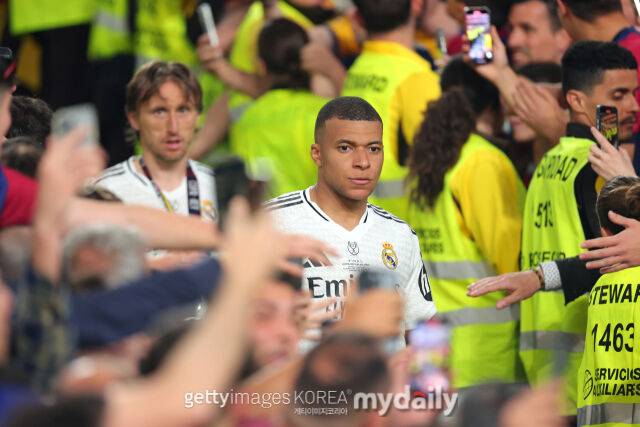 음바페(앞)와 루카 모드리치가 패배 후 씁쓸한 표정을 지으며 퇴장하고 있다. /게티이미코리아