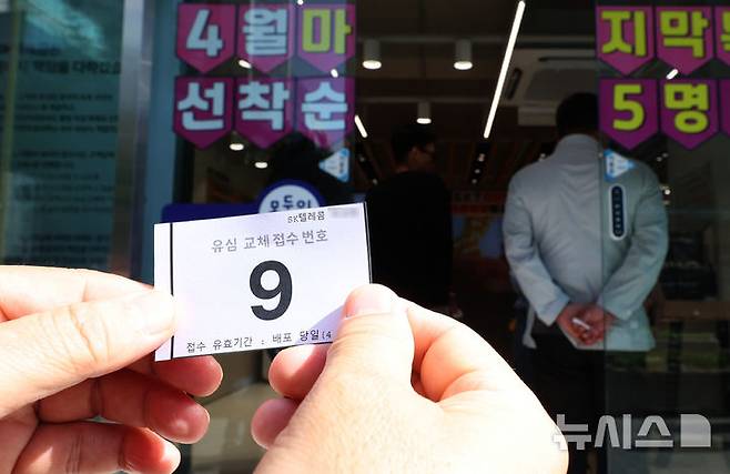 [서울=뉴시스] 이영환 기자 = SK텔레콤이 사이버 침해 피해를 막기 위해 전국 2600여곳의 T월드 매장에서 희망 고객들을 대상으로 유심 무상 교체를 진행하는 28일 오전 서울 시내의 한 T월드 매장에서 한 시민이 번호표를 보여주고 있다. 2025.04.28. 20hwan@newsis.com