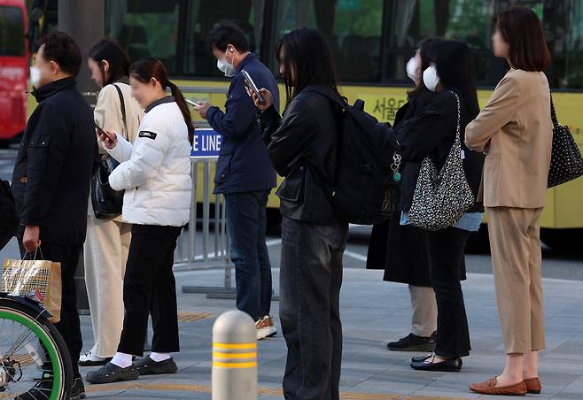 아침 기온이 떨어지며 비교적 쌀쌀한 날씨를 보인 지난 25일 오전 서울 종로구 광화문네거리에서 외투를 걸친 시민들이 신호를 기다리고 있다. 뉴시스