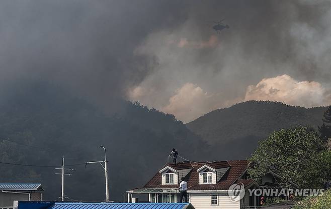 집을 지켜라 (대구=연합뉴스) 윤관식 기자 = 28일 오후 2시 1분께 대구 북구 노곡동 함지산에서 산불이 발생한 가운데 주민들이 주택 지붕에 물을 뿌리고 있다. 2025.4.28 psik@yna.co.kr