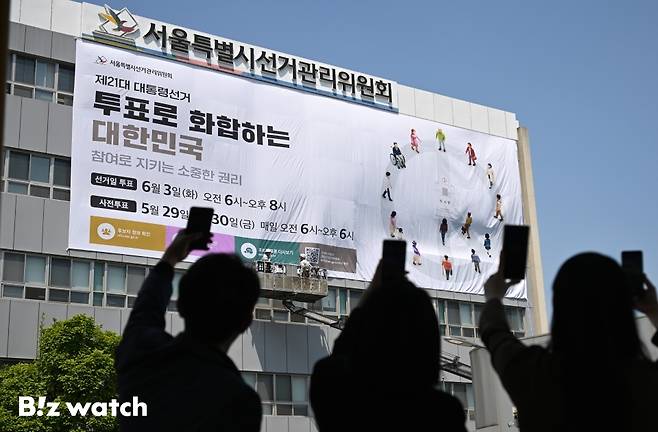 29일 오후 서울 종로구 창경궁로 서울시선거관리위원회 외벽에 관계자들이 제21대 대통령 선거 대형 홍보 현수막을 게시하고 있다./사진=이명근 기자 qwe123@