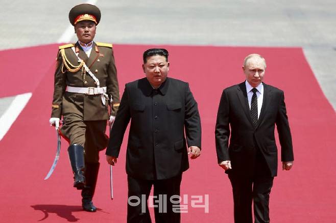 김정은 북한 국무위원장(가운데)과 블라디미르 푸틴 러시아 대통령(오른쪽에서 첫번째)이 지난해 6월 북한 평양 김일성광장에서 열린 공식환영회에 참석해 의장대를 사열하고 있다. [AP통신=뉴시스]