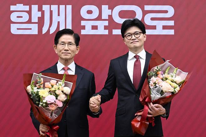 국민의힘 대선 최종 경선에 진출한 김문수(왼쪽)한동훈 후보가 29일 서울 여의도 당사에서 3차 경선 결과 발표 후 꽃다발을 들고서 기념촬영 하고 있다. (사진 = 국회기자단)