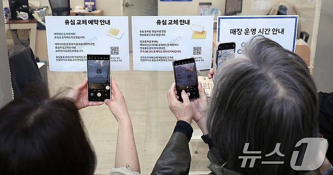 SK텔레콤 가입자 유심(USIM) 정보 해킹 사고 관련 유심 무료교체 서비스 이틀 째인 29일 오전 서울 종로구 T월드 직영 매장 앞에서 번호표를 받지 못한 고객들이 온라인 예약을 하고 있다. 2025.4.29/뉴스1 ⓒ News1 김진환 기자