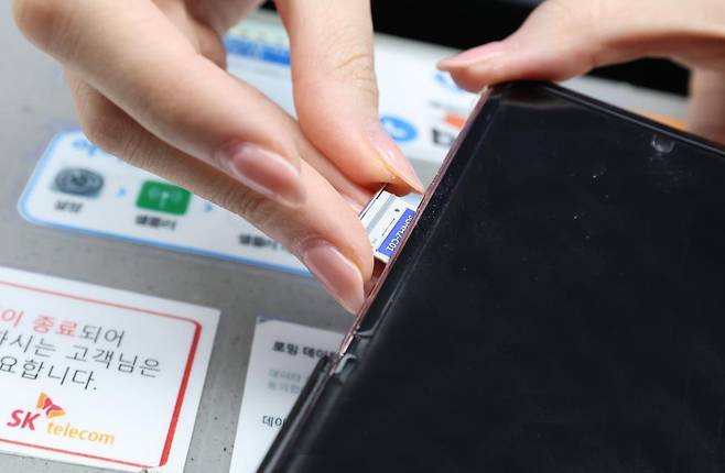 28일 오전 인천공항 제2터미널 SKT매장에서 해킹 공격으로 가입자 유심 정보가 탈취된 SK텔레콤 고객이 유심을 교체하고 있다./뉴스1